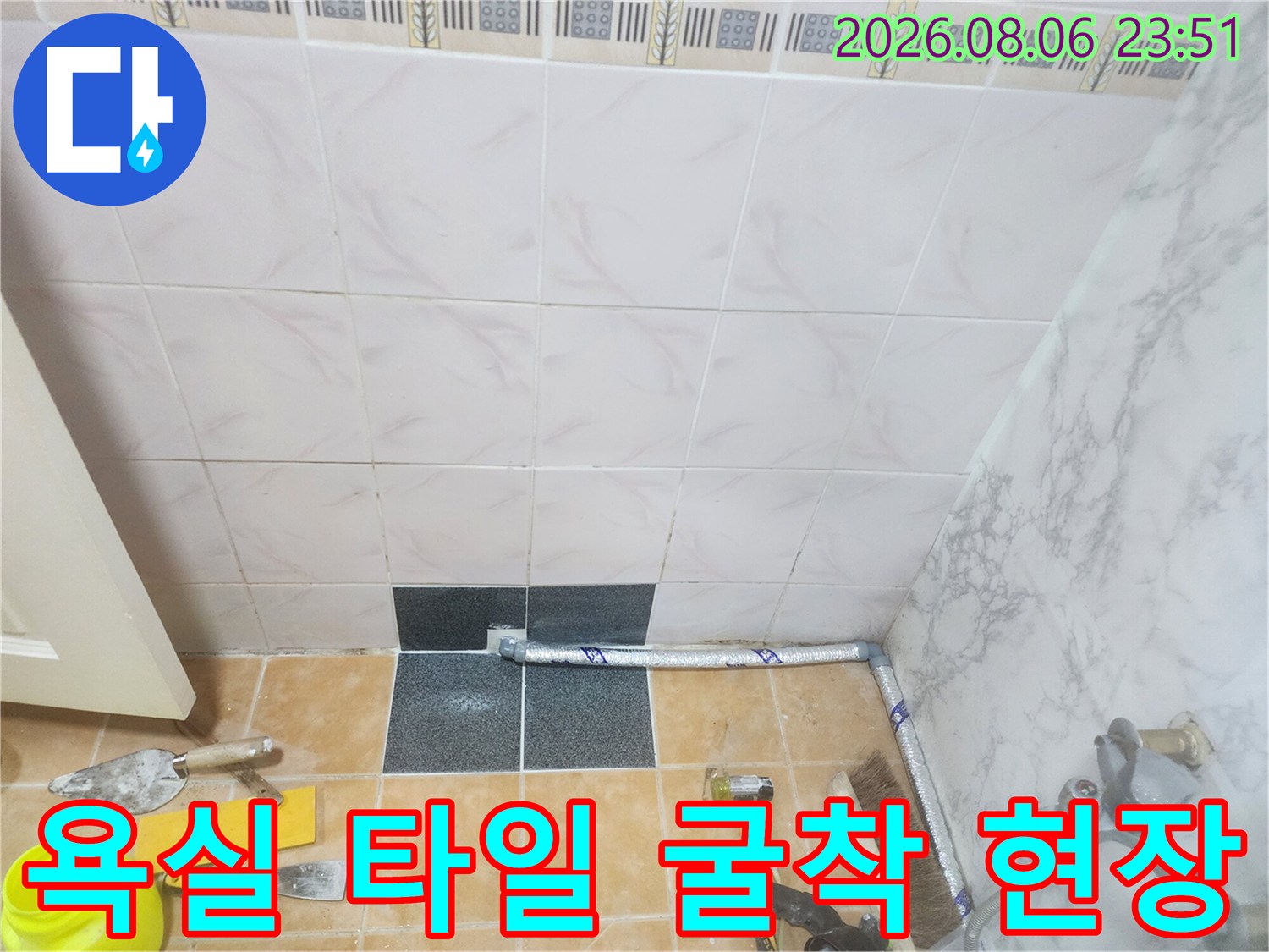 타일을 제거하여 드러난 배관과 작업용 도구들 사진
