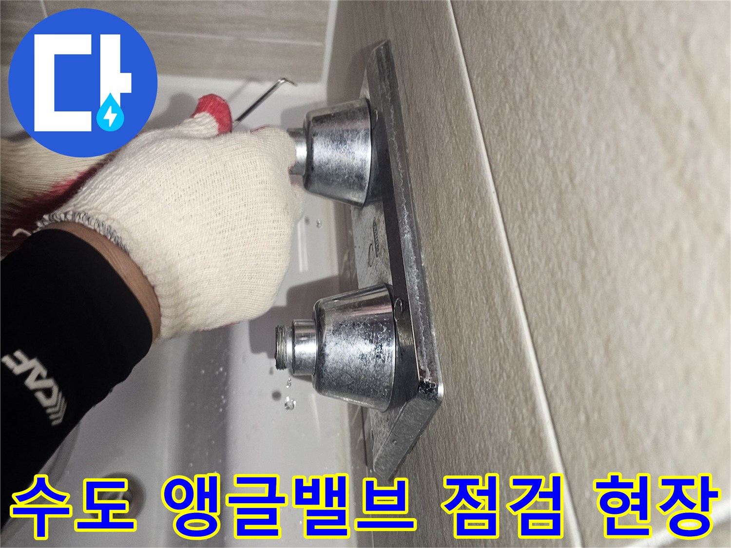 작업자가 장갑을 착용하고 세면대 아래 배관 연결 부위를 점검하는 장면