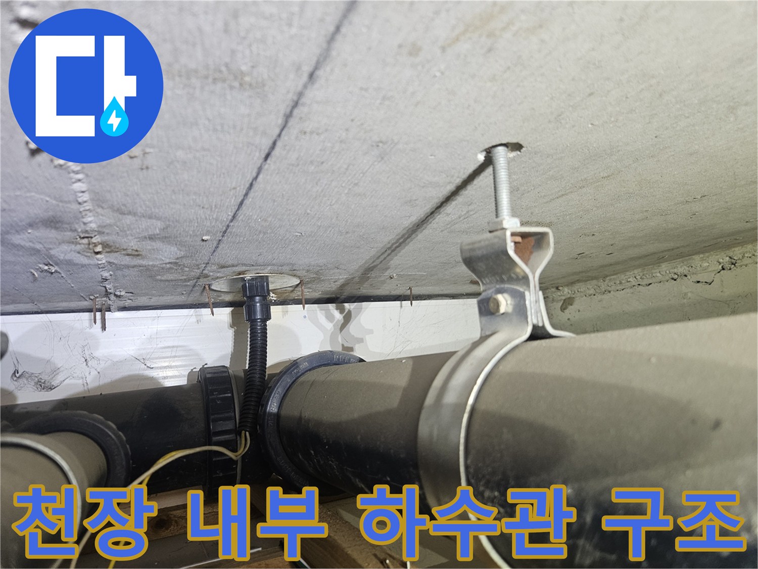 천장에 설치된 검은색 굵은 배관과 금속 고정 장치 상세 사진