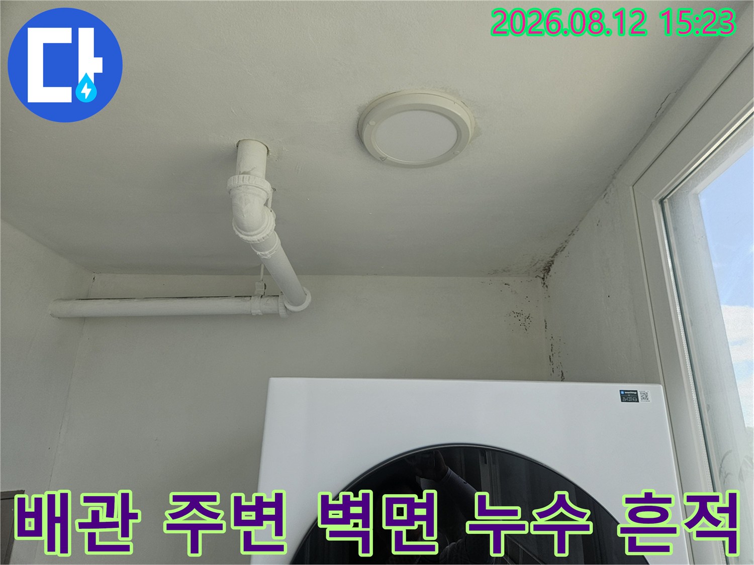 흰색 천장에 노출된 배관-벽면 우측 상단의 어두운 곰팡이 오염
