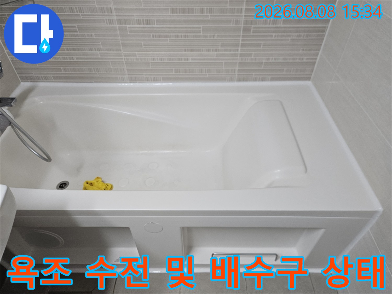 욕실의 하얀색 욕조-샤워기 호스와 배수구 주변을 근접 촬영했습니다.
