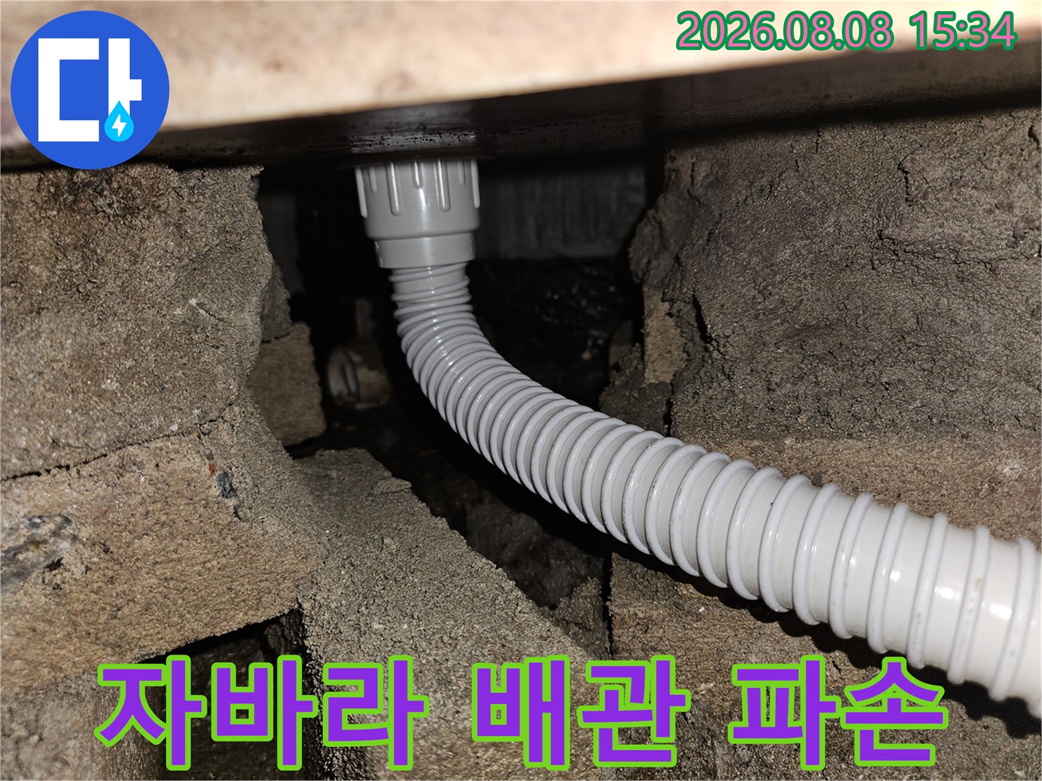 파손된 자바라 배관과 젖은 주변 구조물의 근접 사진입니다.
