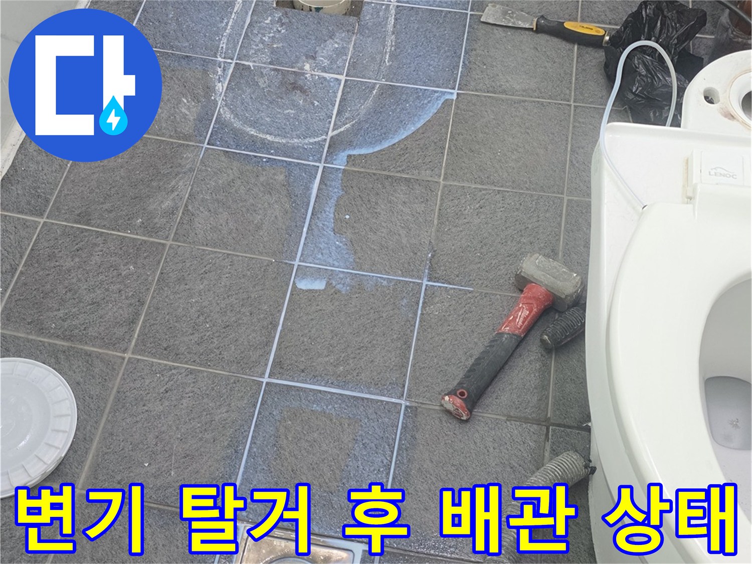 양변기를 제거하고 드러난 배수관과 오염된 바tes 타일 바닥면