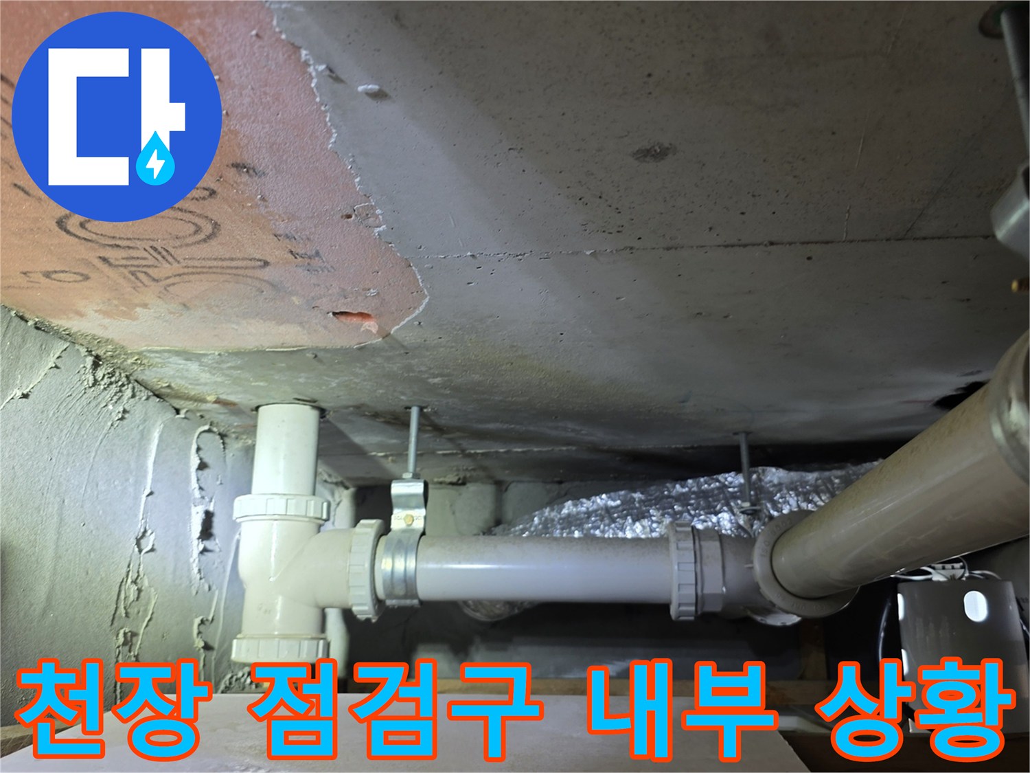 점검구를 통해 바라본 천장 내부의 배관 및 구조물