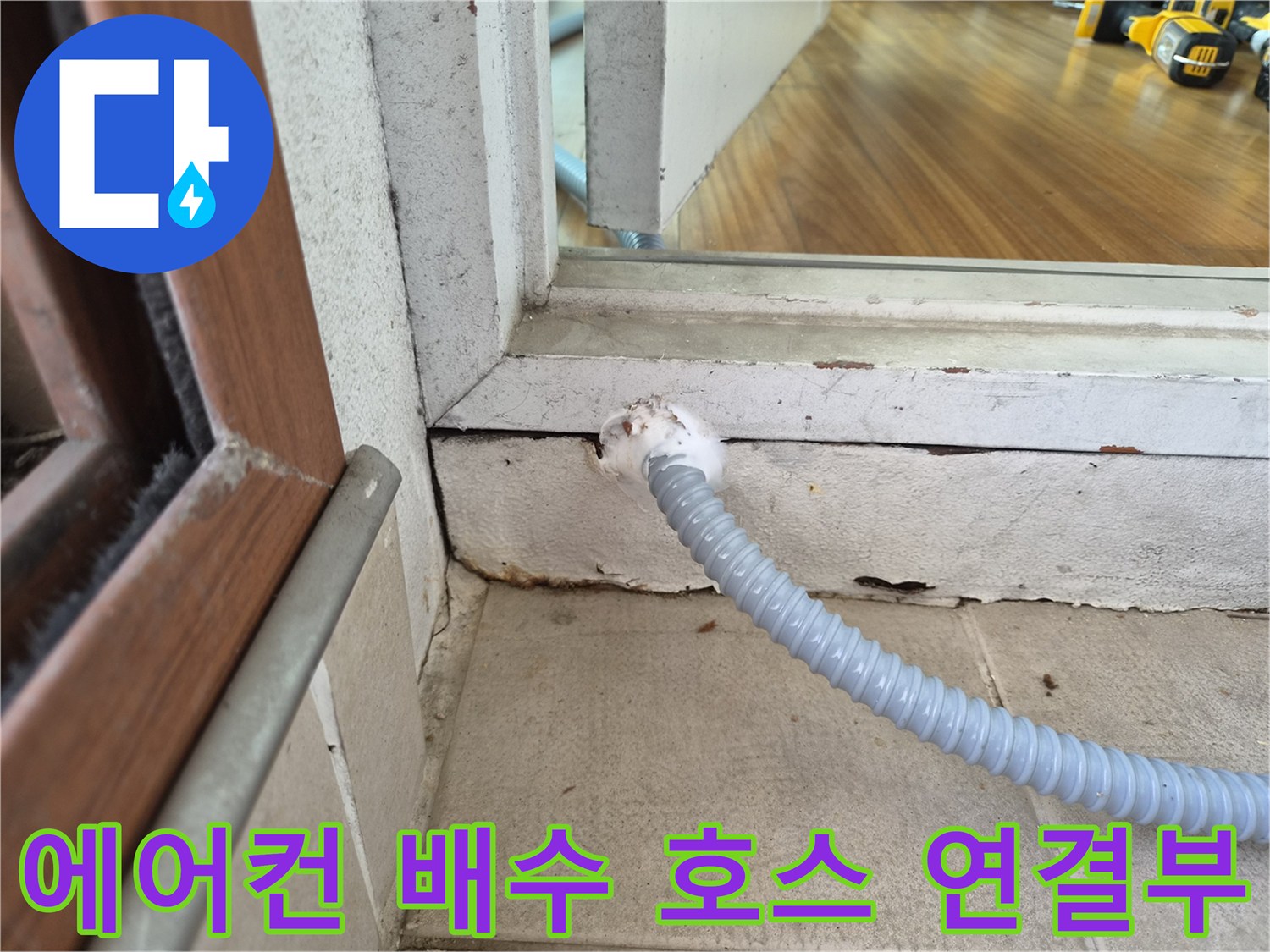 에어ca 배수 호스가 베란다 벽면 틈새로 연결된 모습입니다.