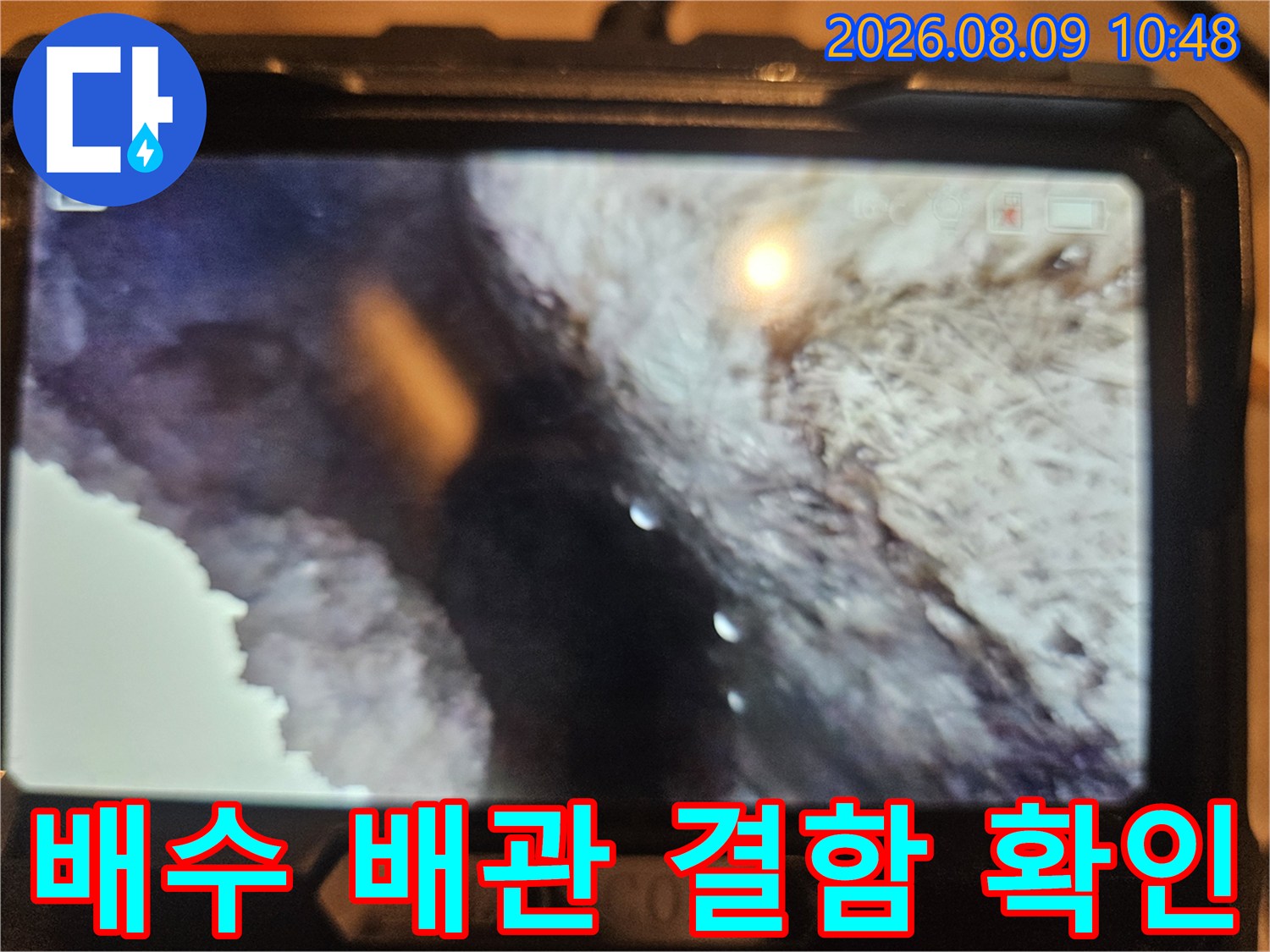 어두운 천장 내부의 배관 연결 부위를 내시경으로 촬영한 모습입니다.