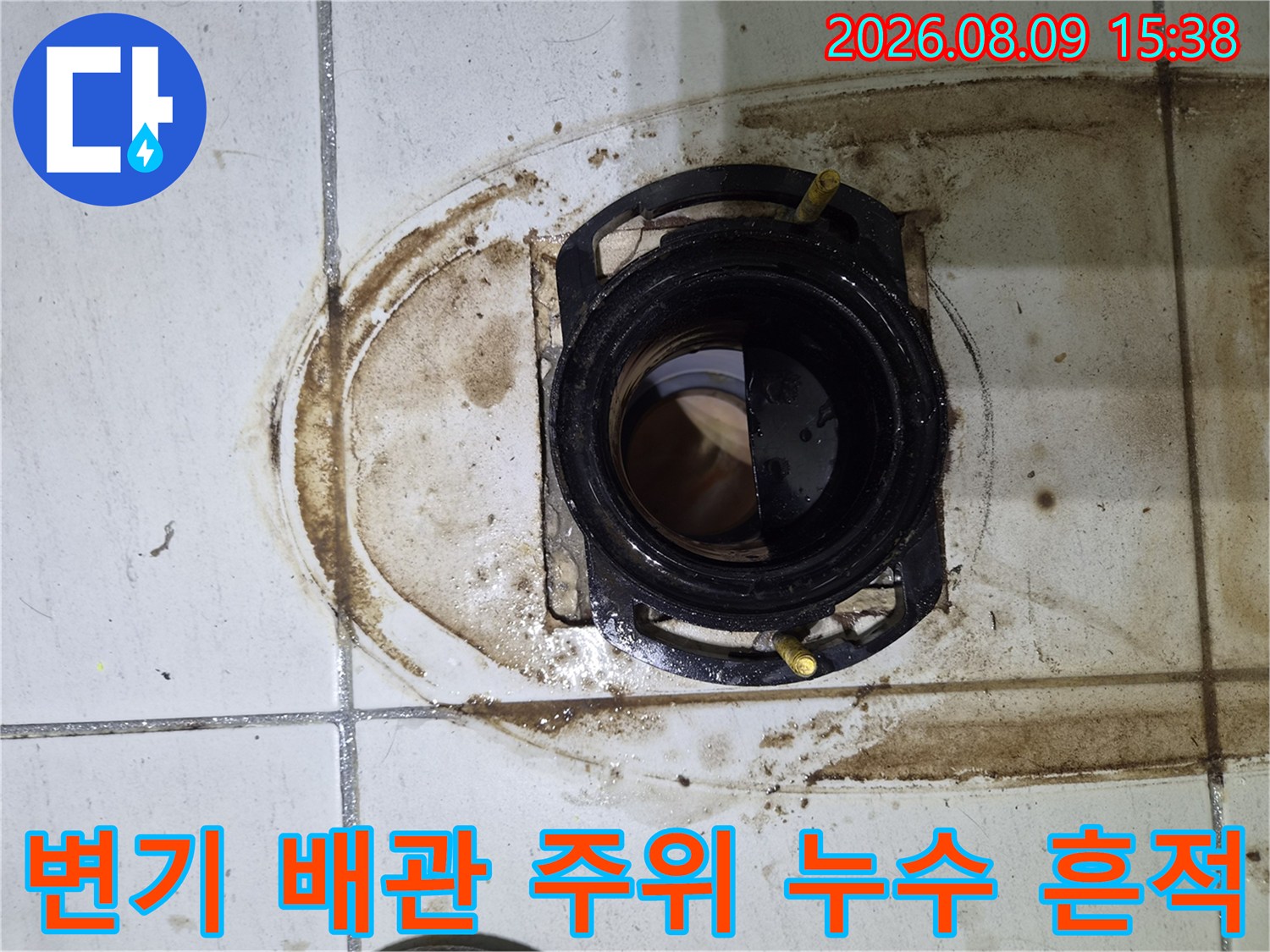 변기 탈거 후 노출된-배관 주변의 심한 오염과 얼룩진 타일입니다