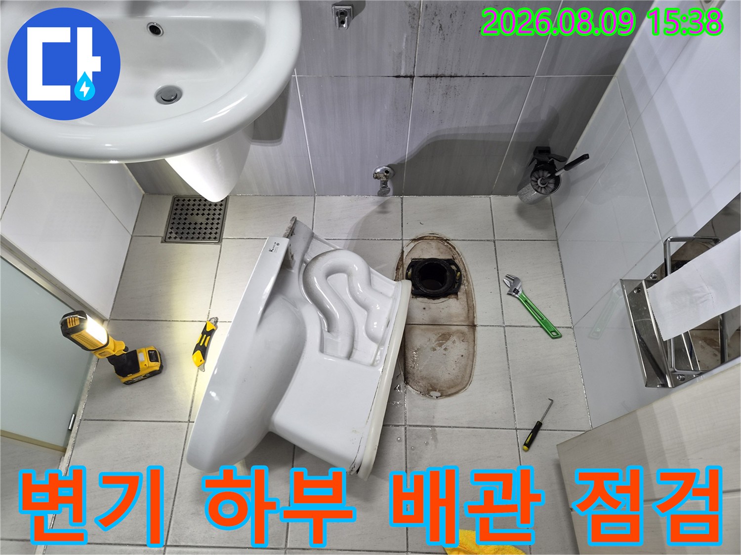 변기 하부의 오물 배측 배관과 주변 타일의 오염 상태를 보여줍니다.