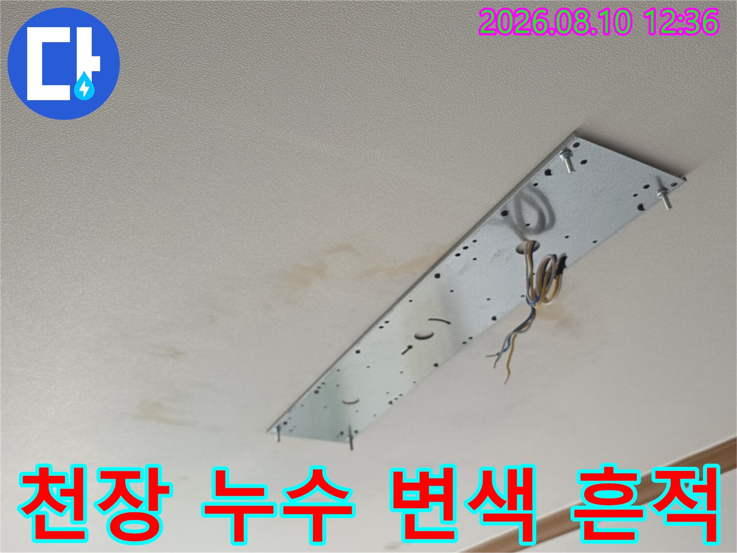 천장 마감재 주변의 갈색 누수 얼룩과 전기 배선