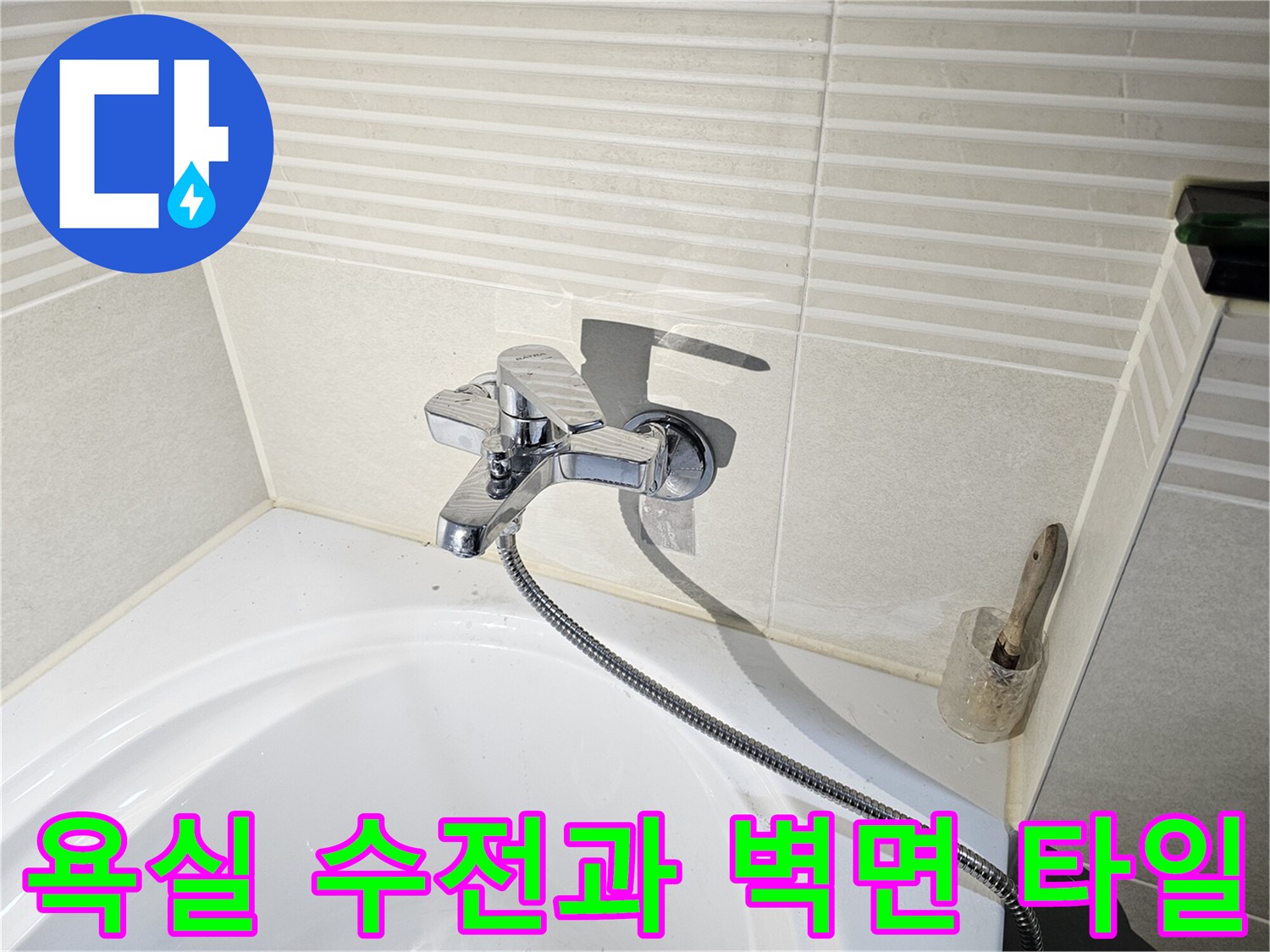 욕조 옆 벽면에 설치된 은색 수전-샤워기 호스 연결 부위