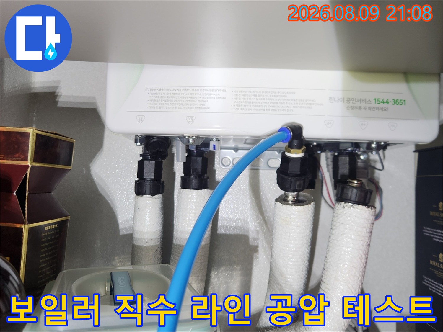 보일러 하단 흰색 보온재 배관에 파란색 측정 호스가 연결된 사진