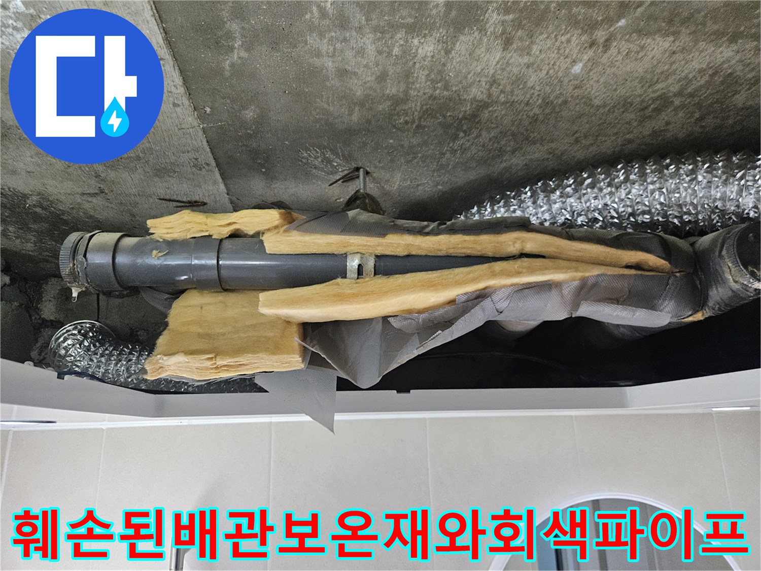 천장-내부의-노란색-단열재가-찢어져-나온-회색-배수관-모습