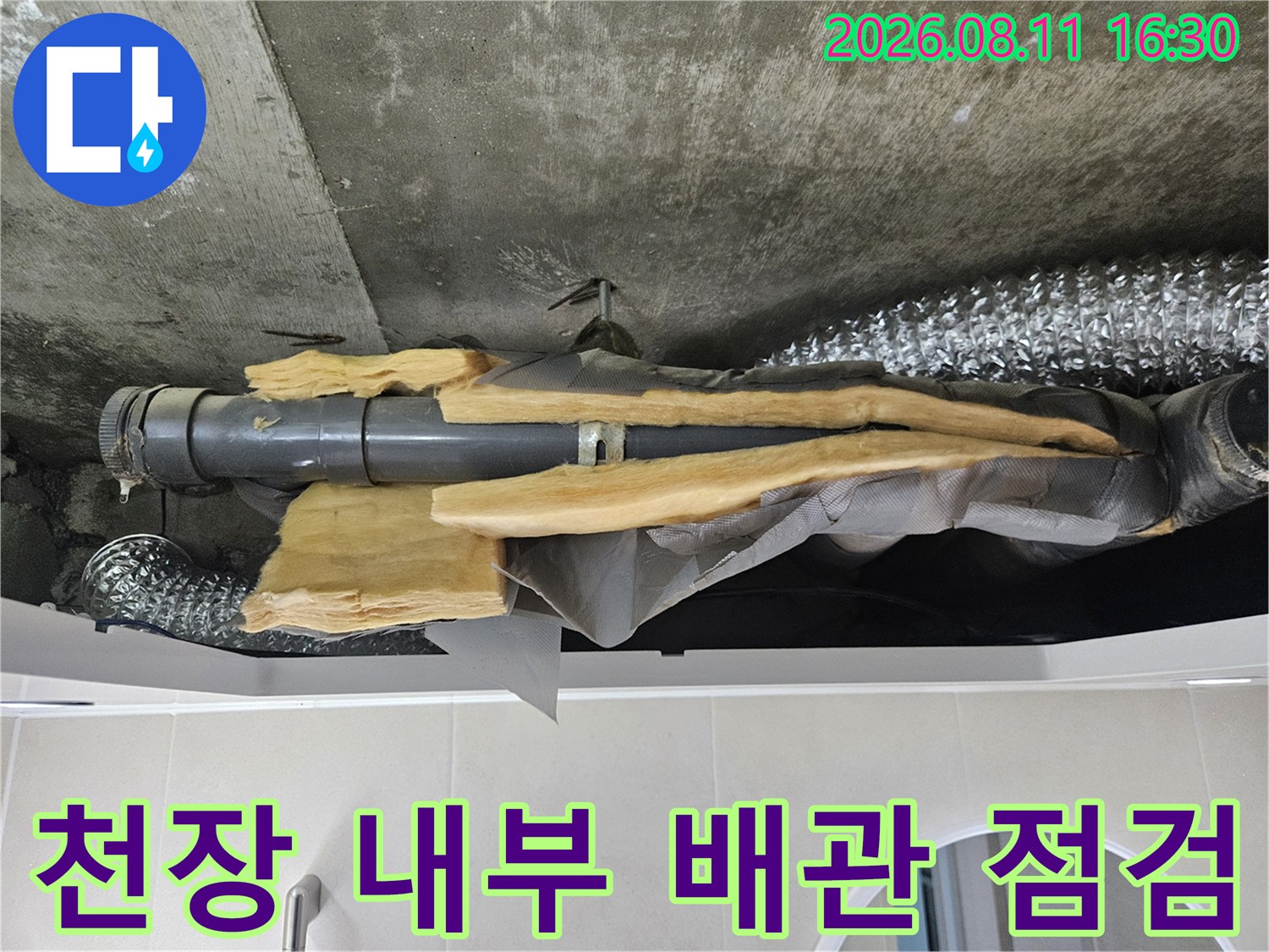 천장 속 은박 보온재가 감겨 있는 배관과 주변 습기를 촬영한 사진입니다.