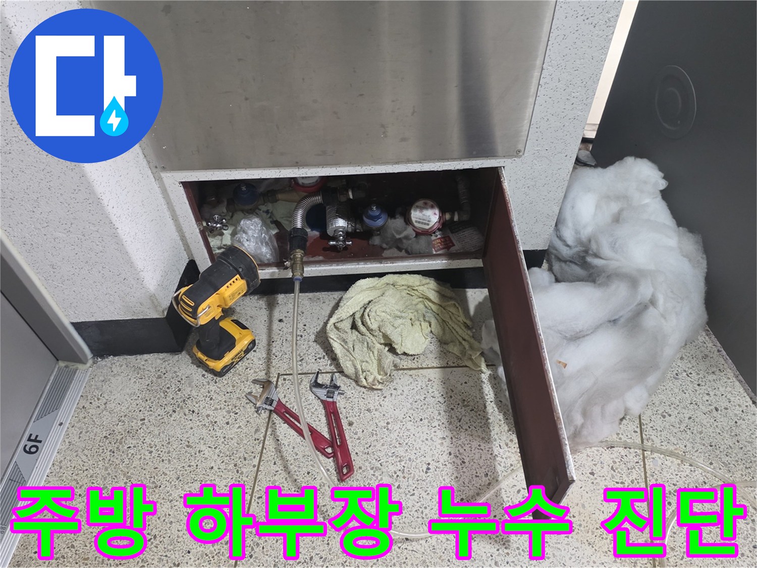 싱크대 아래쪽의 배관 연결 상태를 확인하기 위해 배치된 작업 도구들 사진