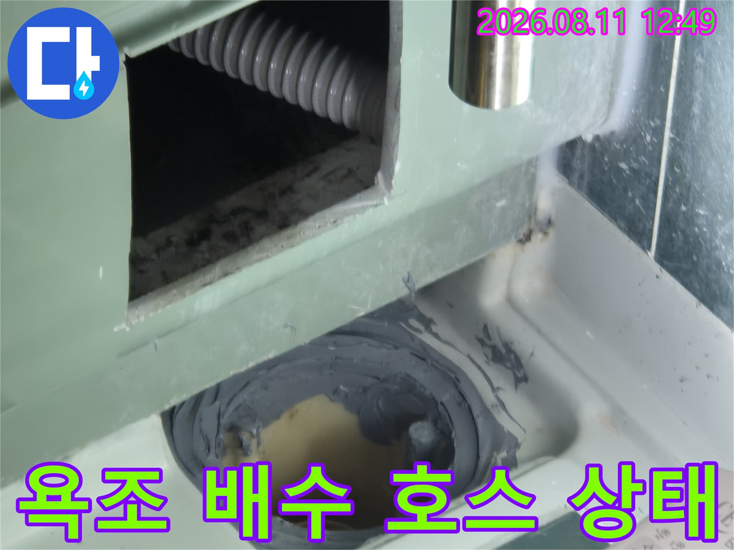 절개된 공간 내부에 위치한 주름관 형태의 배수 호스입니다.