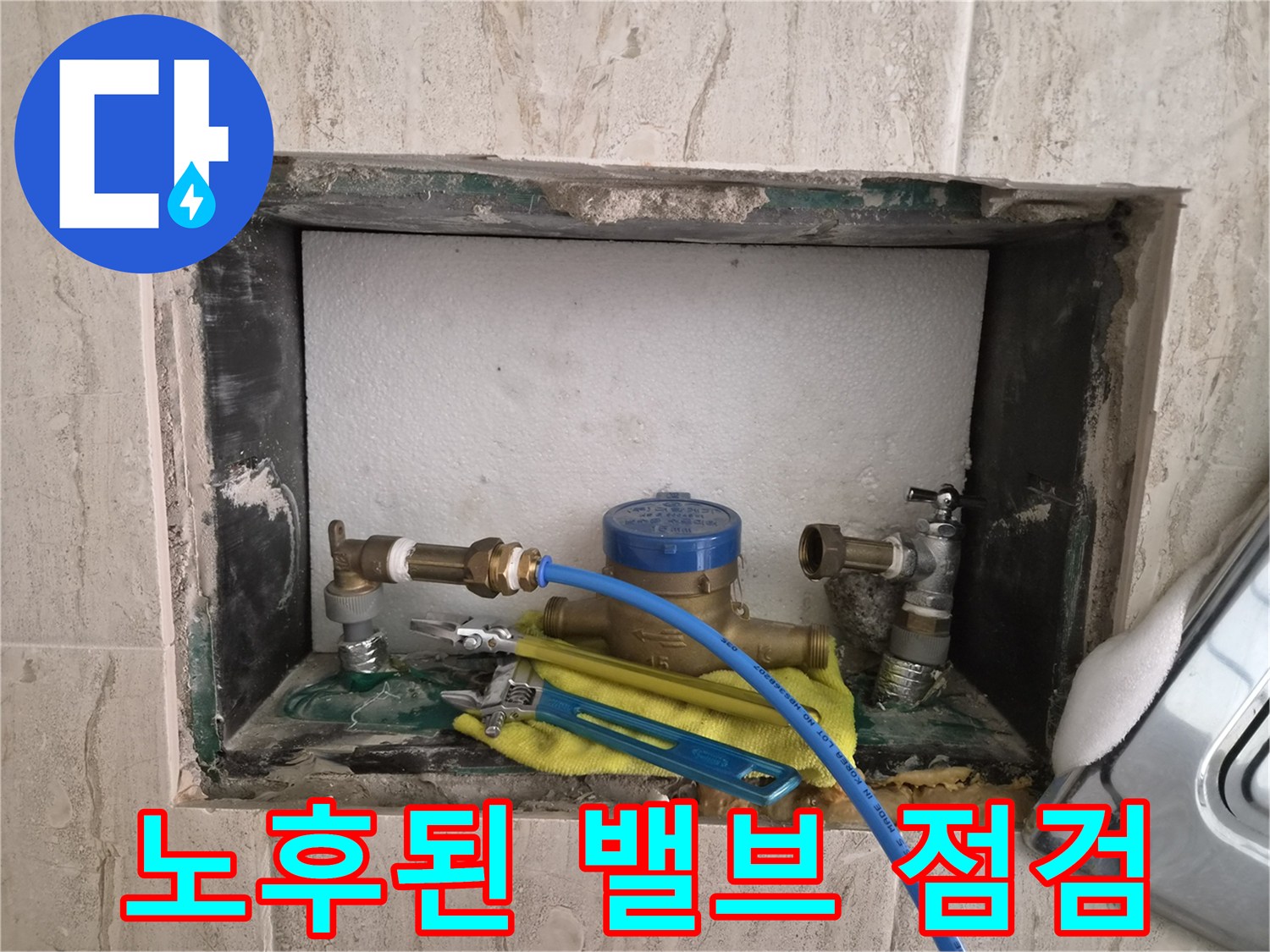 벽면 매립 공간 내 설치된 수도 부속과 작업 도구들