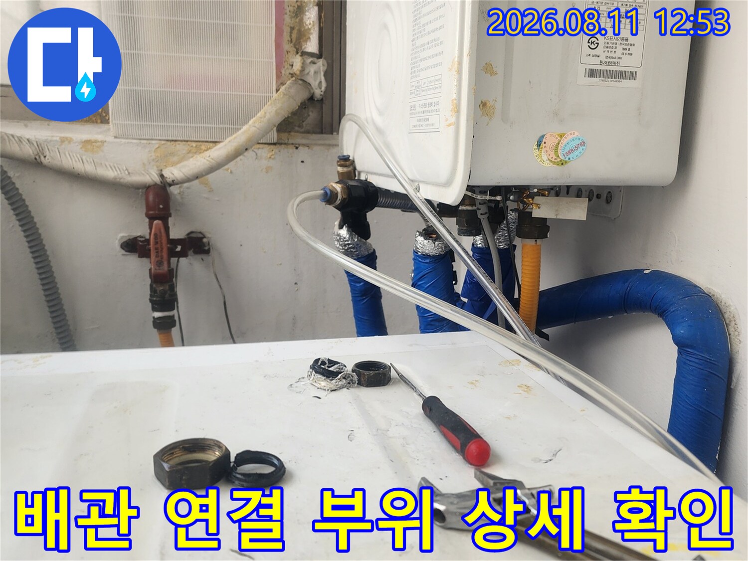 보일러 아래 배관의 밸브와 연결 부위를 집중적으로 촬영한 사진입니다