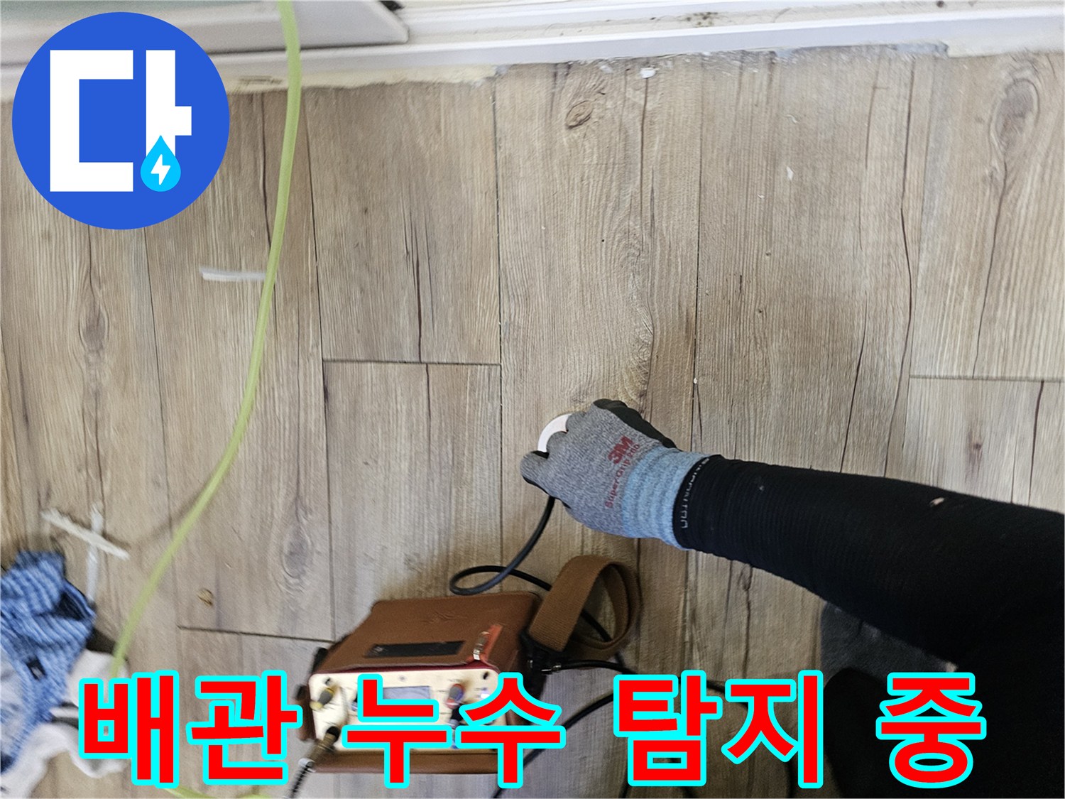나무 마루 위에서 배관 압력을 체크하는 전문 장비와 호스