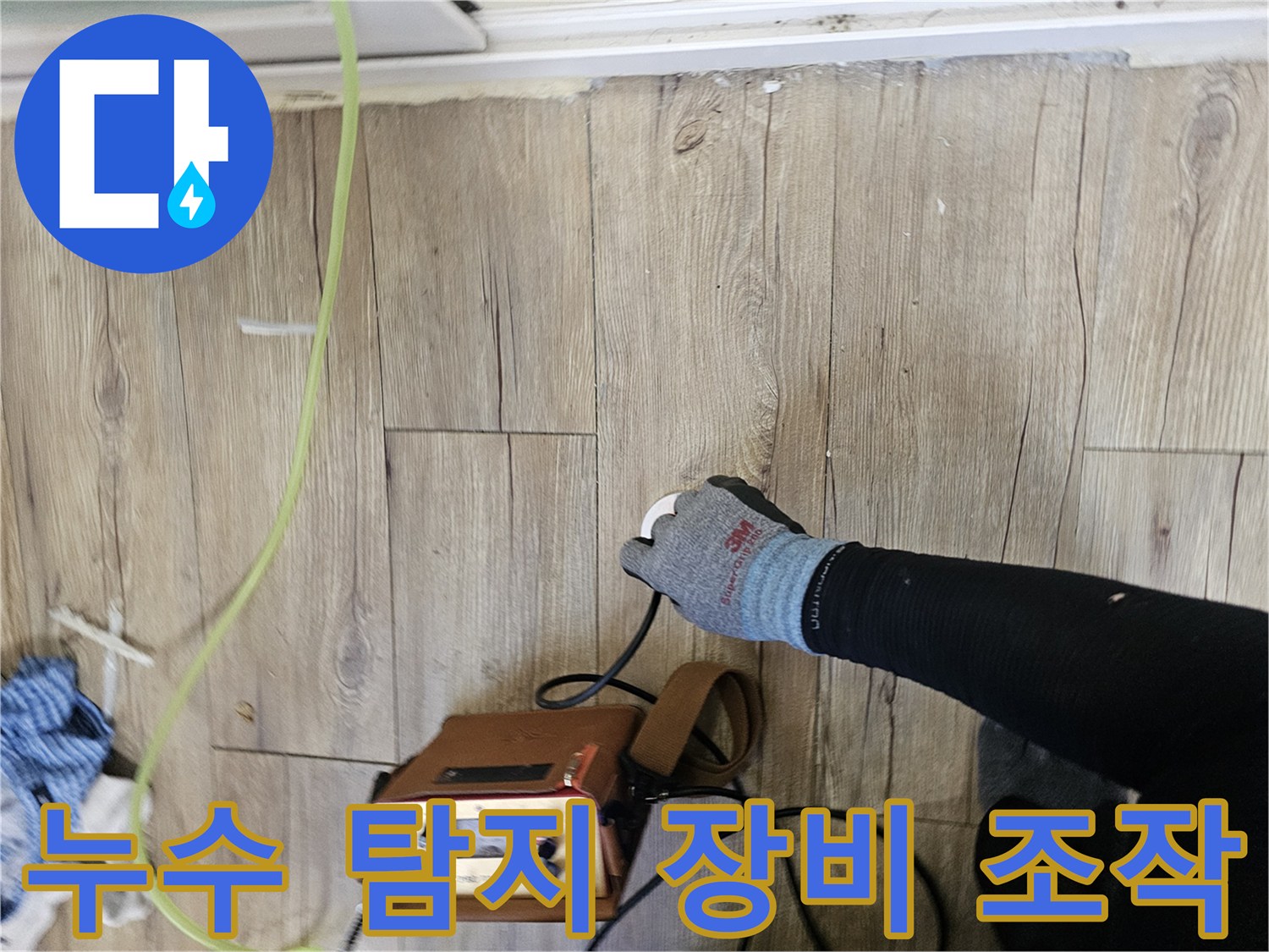 장갑을 낀 작업자가-배관 탐지기를 바닥에 대고 있는 모습