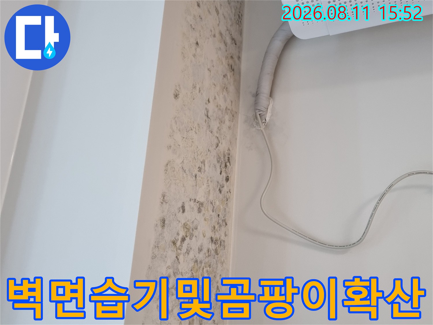 에어컨 실내기 하단 배관 주변의 벽지가 누수로 인해 갈색으로 변색된 모습