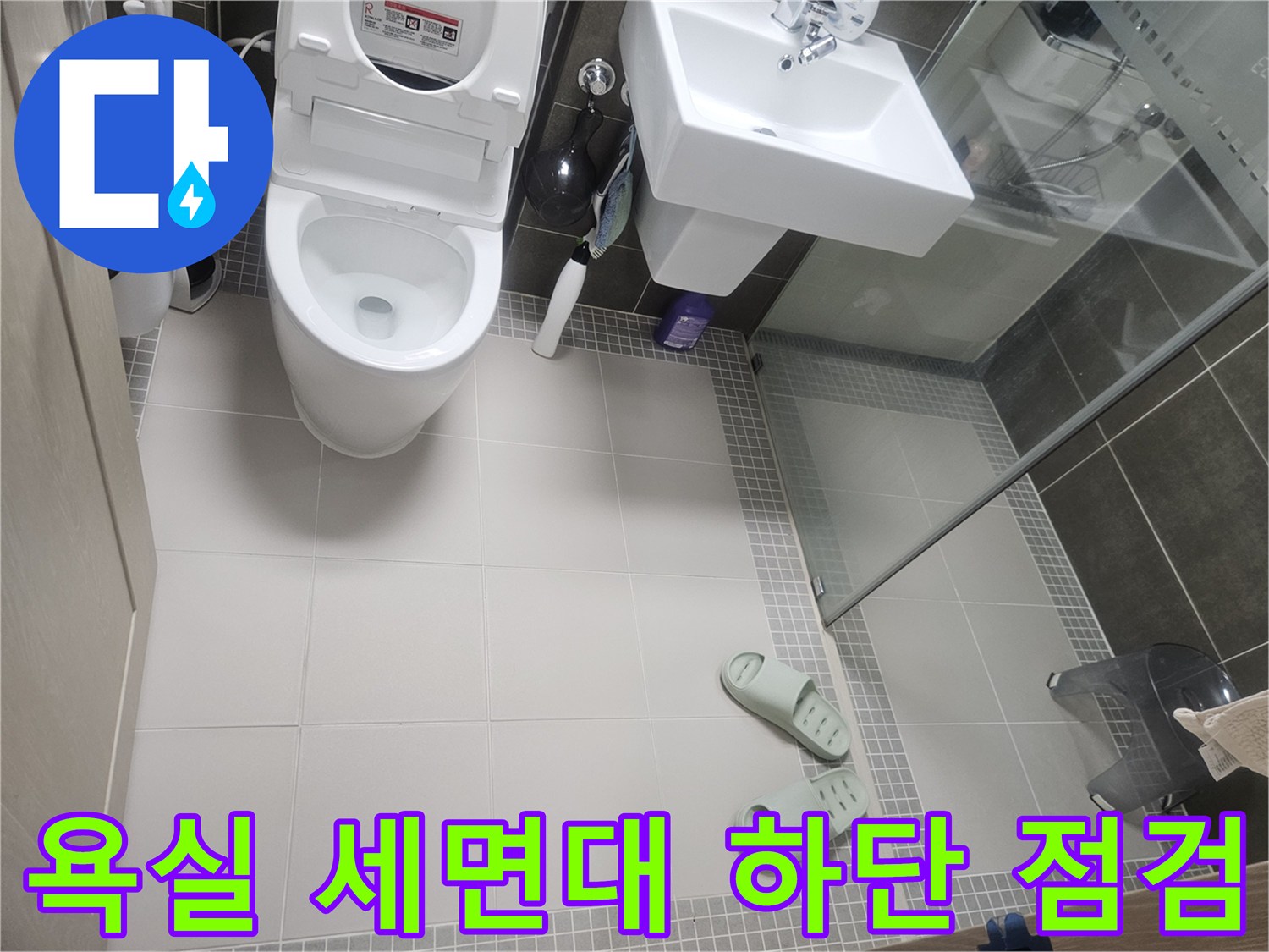 세면대와 변기 주변의 타일 마감 상태를 촬영한 사진입니다.
