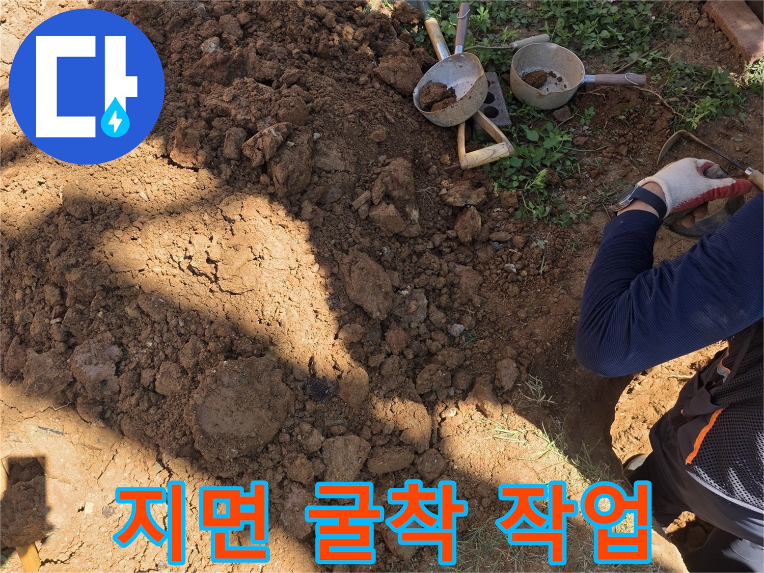 배관 수선을 위해 흙을 파내고 도구를 배치한 모습입니다.