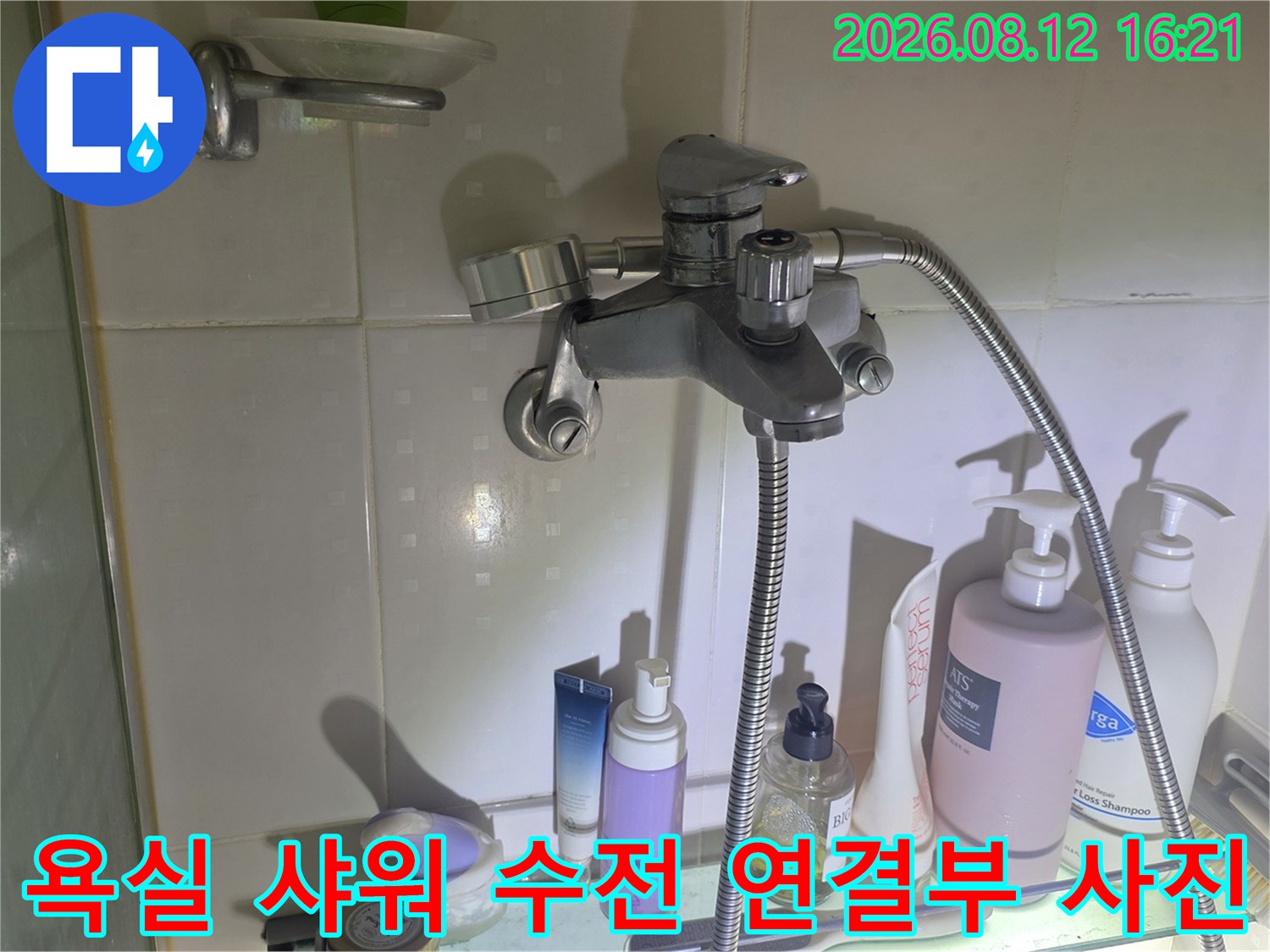 욕실 벽면에 설치된 금속 재질의 샤워기 수전과 배관 연결 부위-정밀 점검 모습
