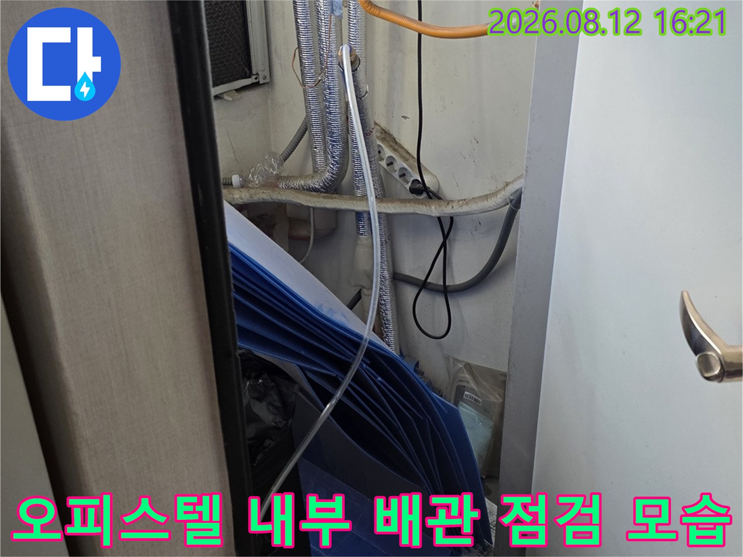 흰색 보온재로 감싸진 배관과 파란색 단열재가 설치된 천장 하부 구조-누수 점검 현장