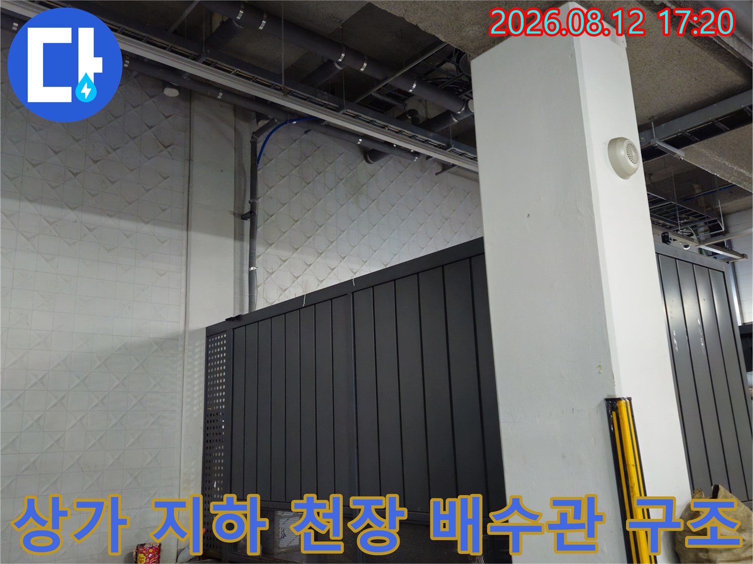 상가 지하 주차장의 노출된 천장 배관과 벽면 마감 상태입니다.