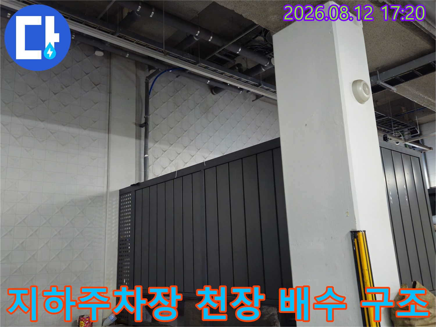 상가 지하 주차장의 노출된 천장 배관과 벽면 마감재 모습입니다.