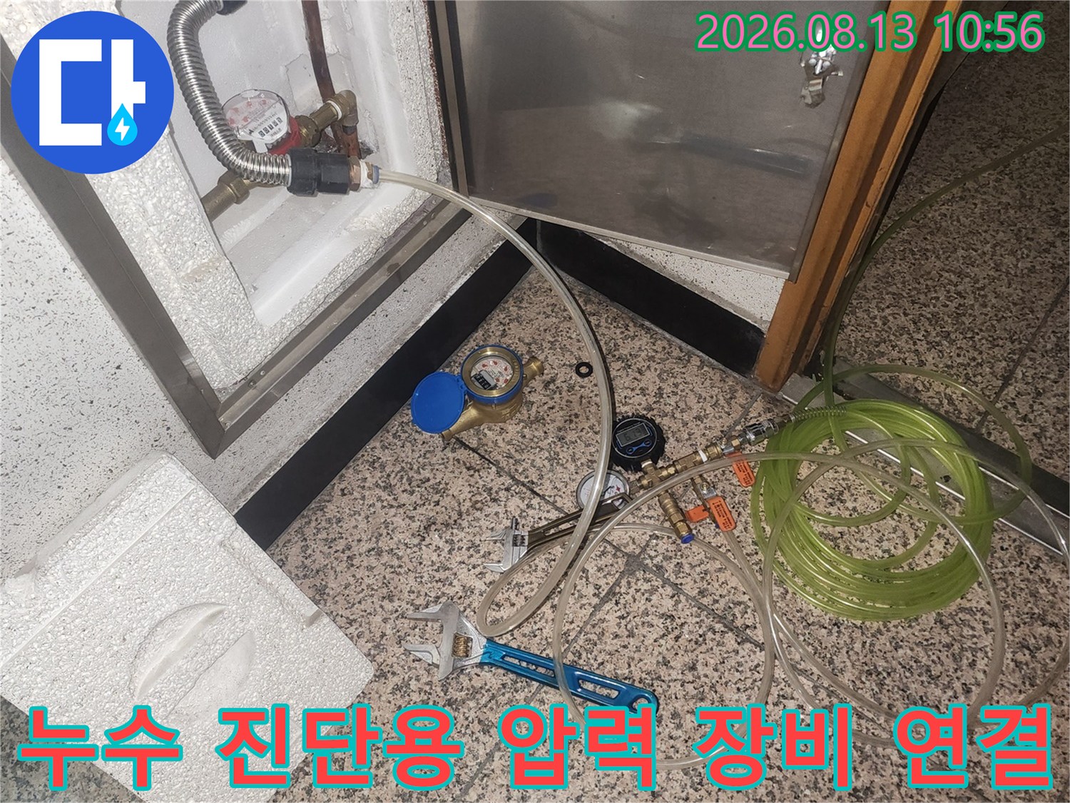 흰색 스티로폼 마감재 안쪽 배관에 투명 튜브와 측정기가 설치된 장면