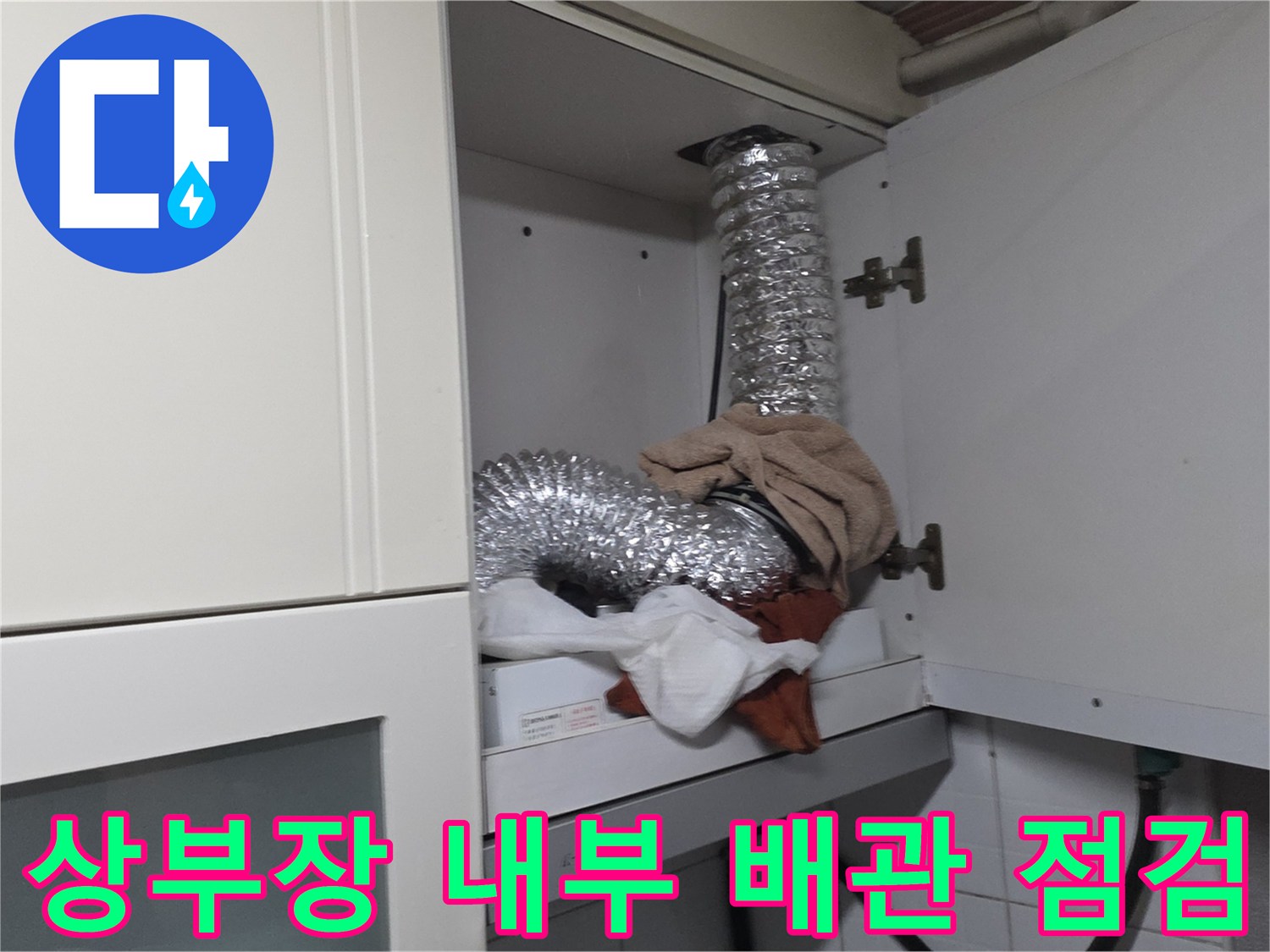 주방 상부장 내부에 노출된 은박 자바라 배관과 주변 마감재
