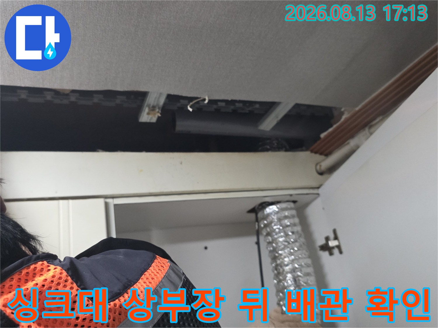 주방 싱크대 상부장 뒷면의 노출된 배관과 천장 구조물 점검 모습
