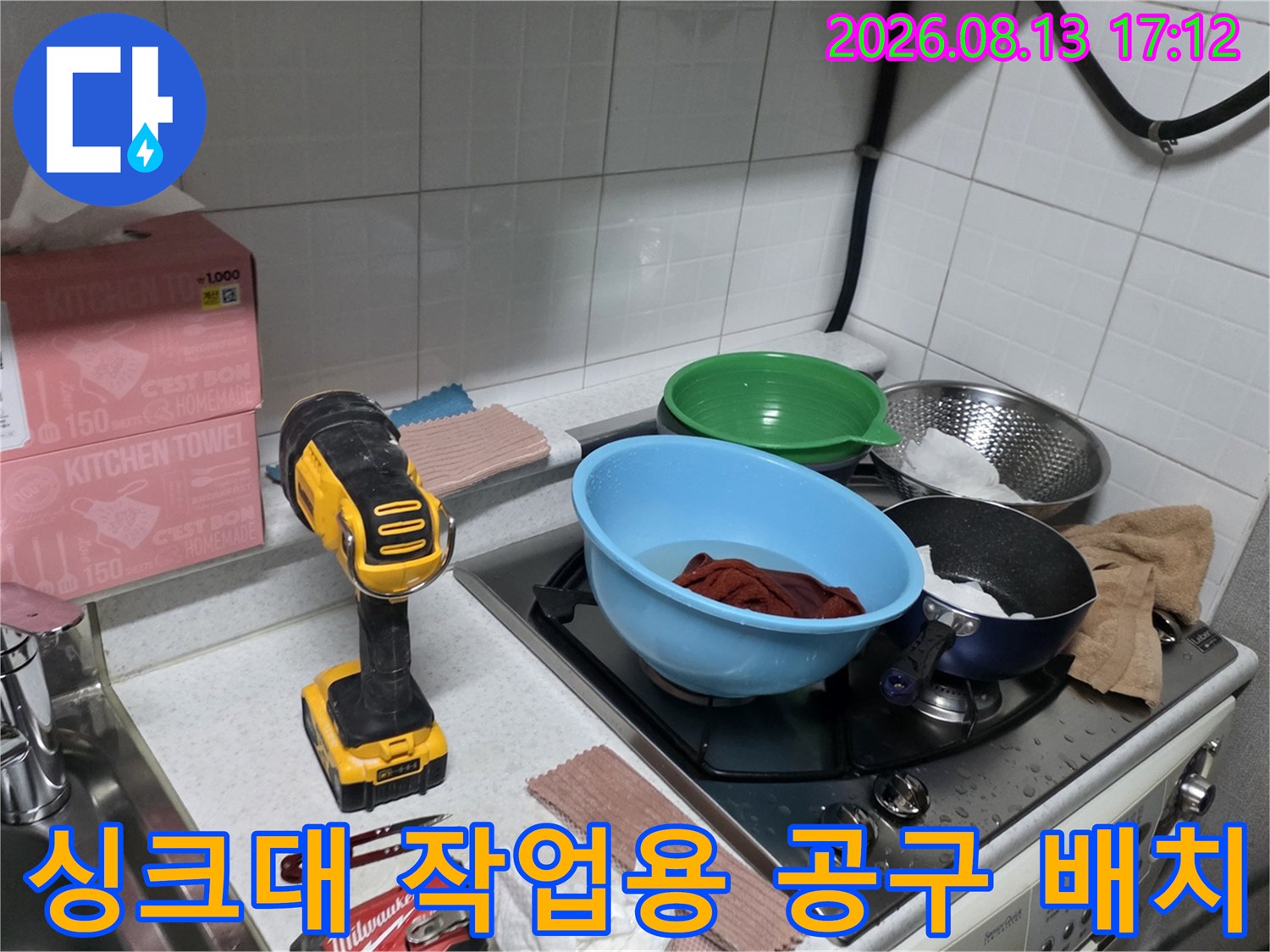 주방 싱크대 조리대 위에 놓인 전동 드릴과 수공구 세트
