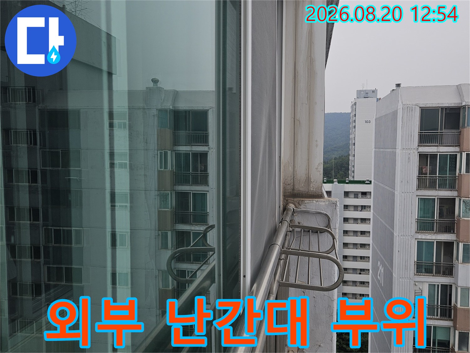 아파트 외부 난간대와 배관 연결 지점의 틈새를 세밀하게 관찰합니다.