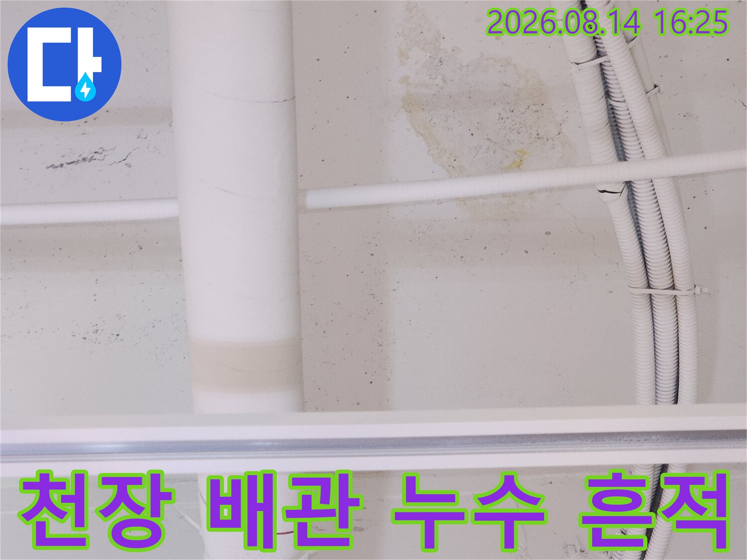 천장 마감재에 나타난 갈색 누수 얼룩과 배관 시설물