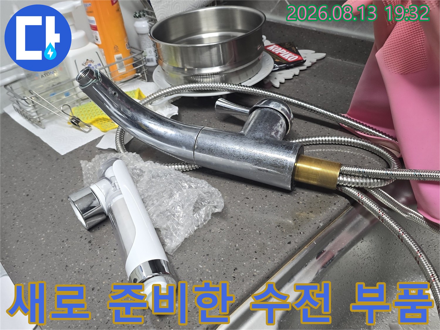 교체용으로 준비된 은색 싱크대 수전 헤드와 금속 급수 호스 상세 사진입니다.