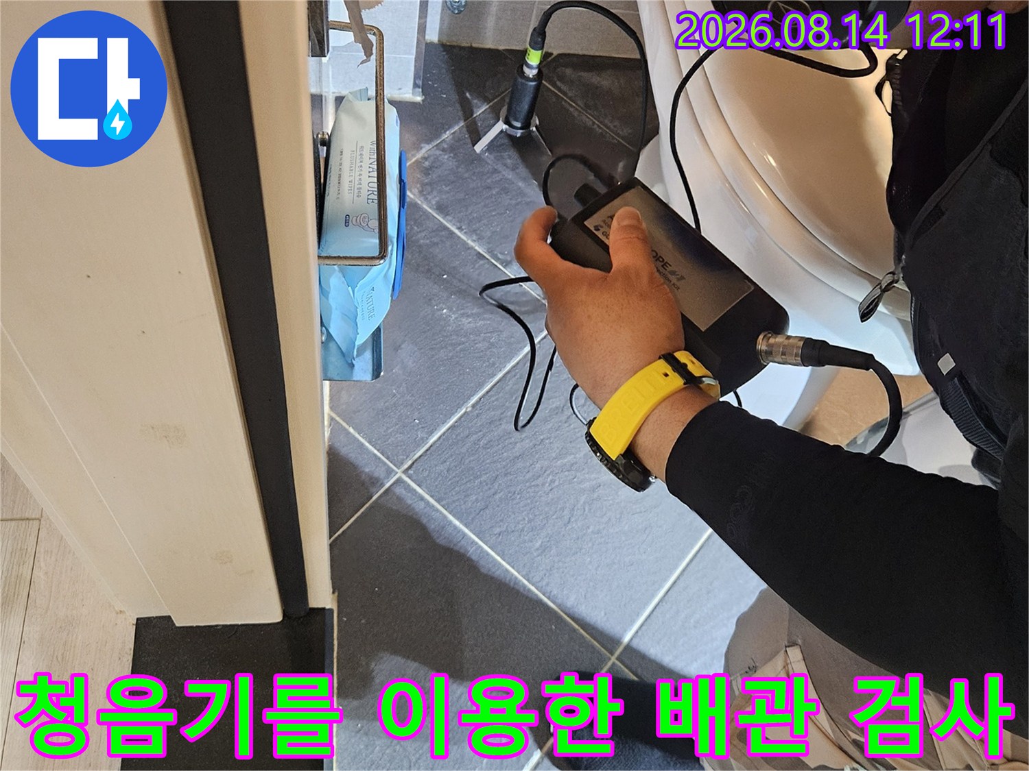 헤드셋과 청음 장비를 사용하여 배관의 누수 지점을 찾아내는 모습입니다.