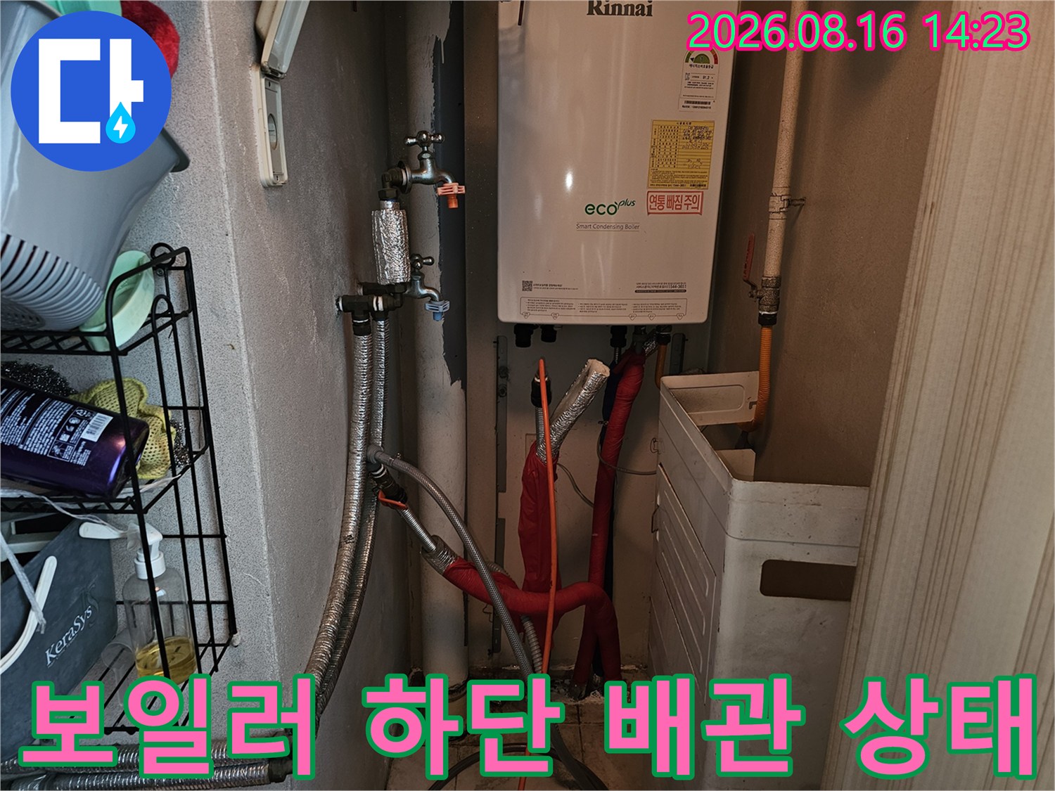 보일러 아래쪽의 다양한 연결 부속과 밸브가 노출된 모습입니다.