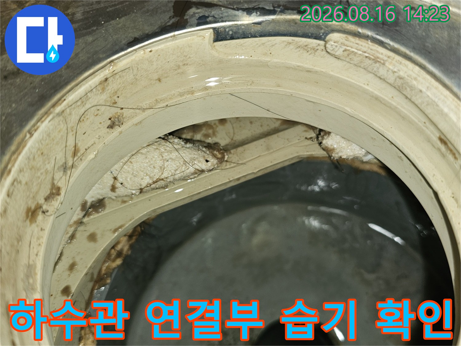 하수구 배관 주변에 발생한 물때와 젖은 흔적을 자세히 촬영했습니다.