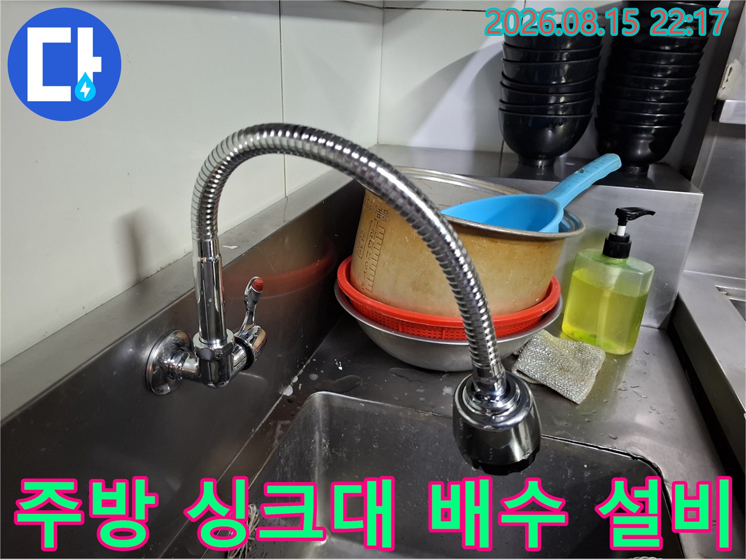 식당 내부의 스테인리스 싱크대와 수전 장치입니다.