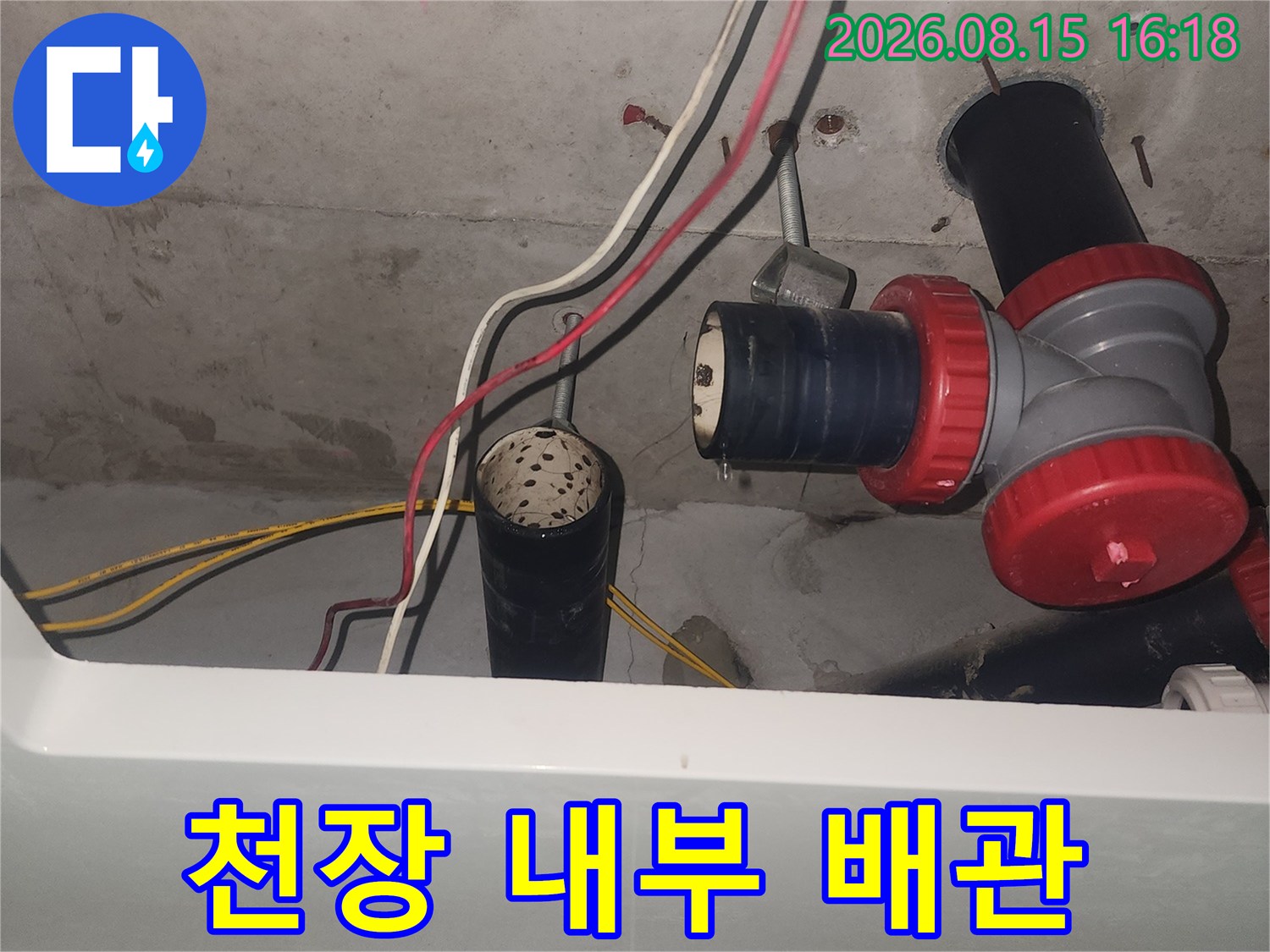 화장실 천장 배관 - 붉은색 부속과 검은색 관 연결부