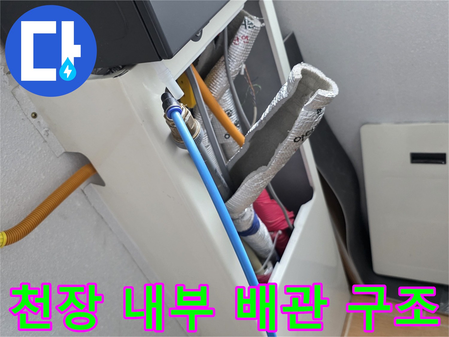 파란색 배관과 은박 보온재가 설치된 화장실 천장 내부 사진