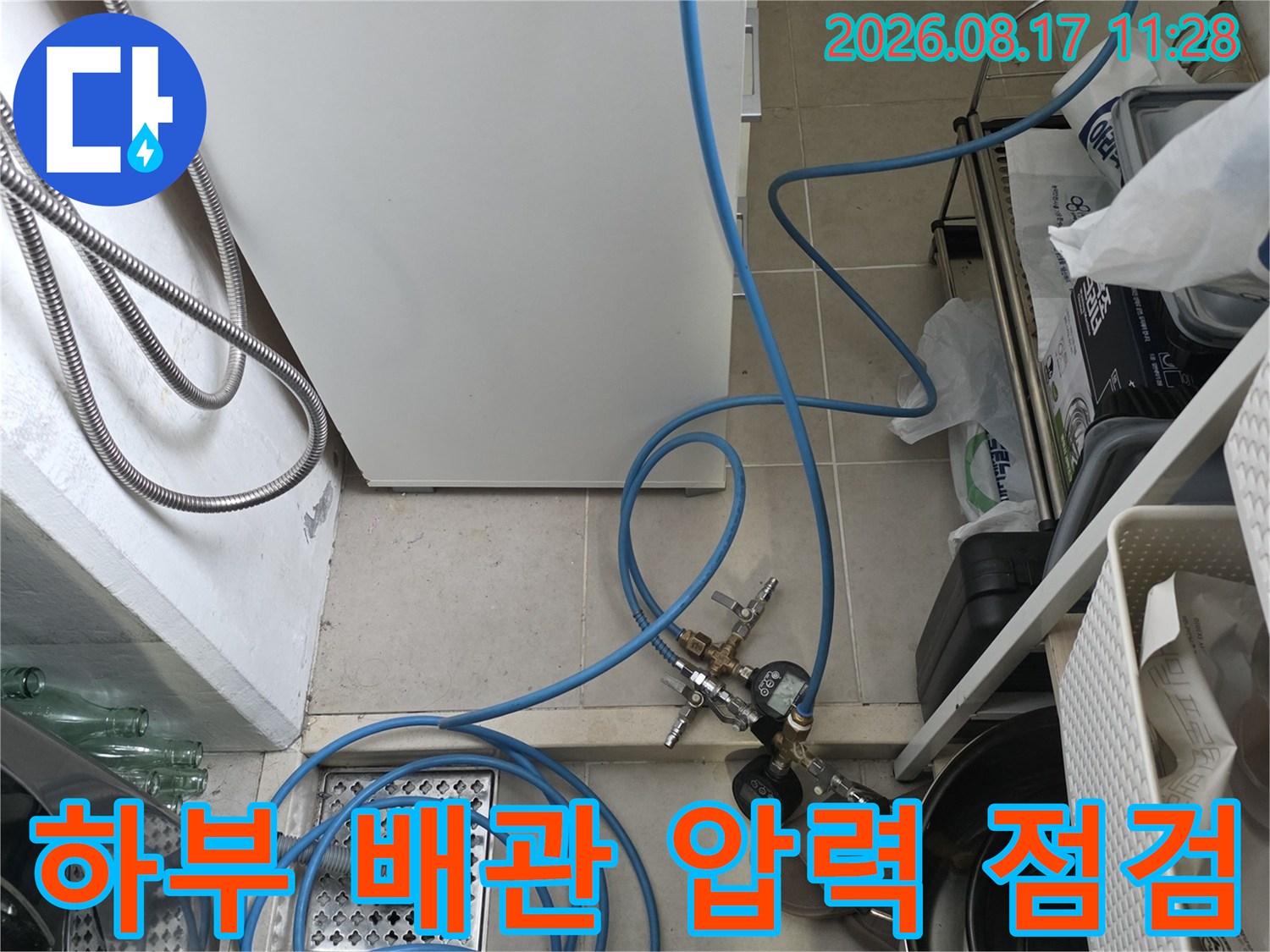싱크대 하단 배관에 연결된 파란색 호스와 측정 장비