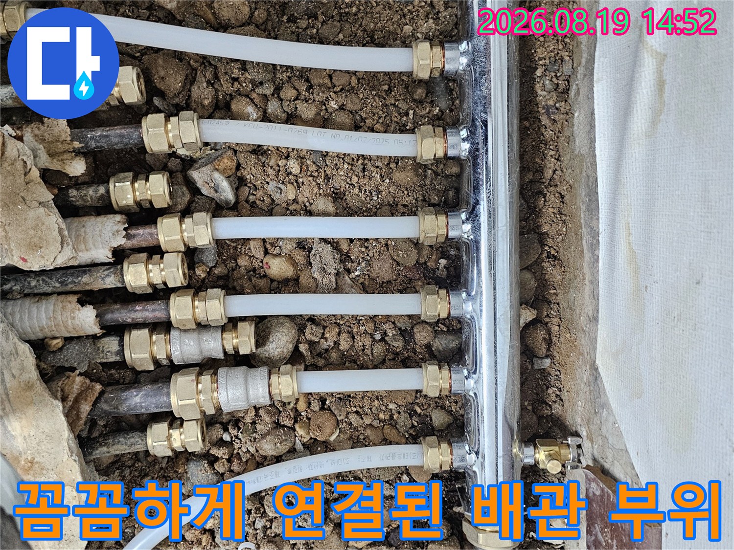 새로운 연결 부속을 사용하여 재결선된 난방 배관과 분배기의 상세 사진입니다.