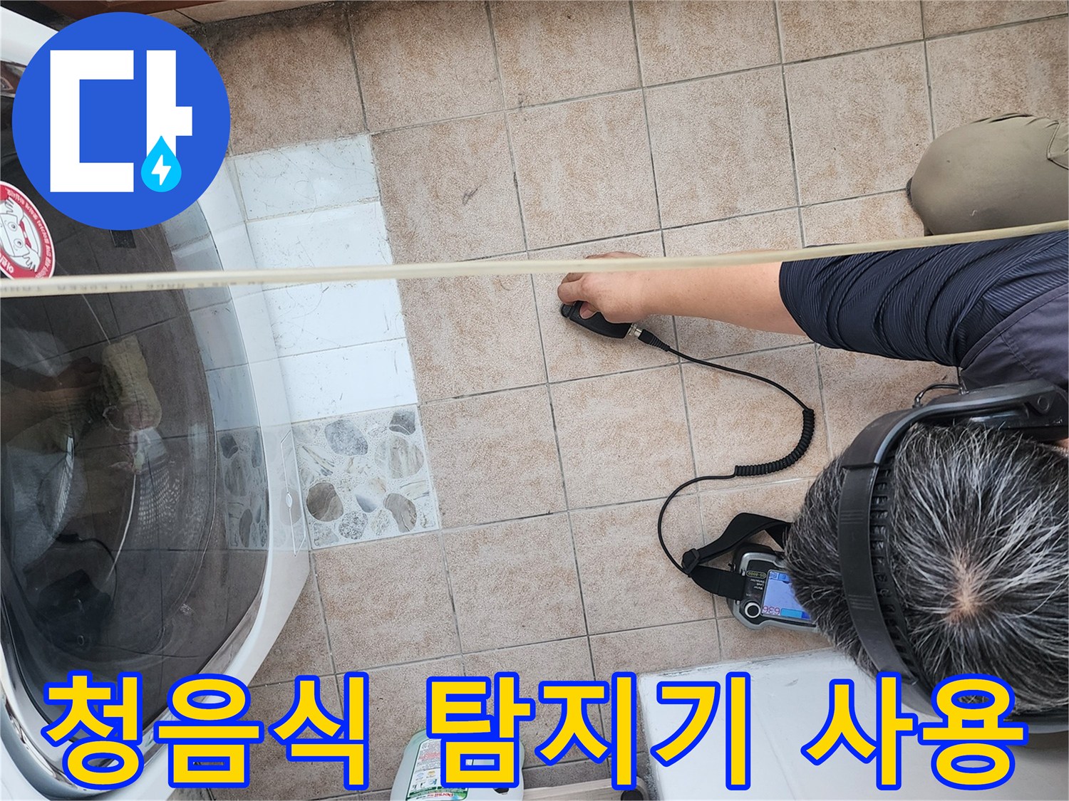 세탁실 바닥에서 청음식 누수 탐지기를 사용하여 물샘 지점을 찾는 모습입니다.
