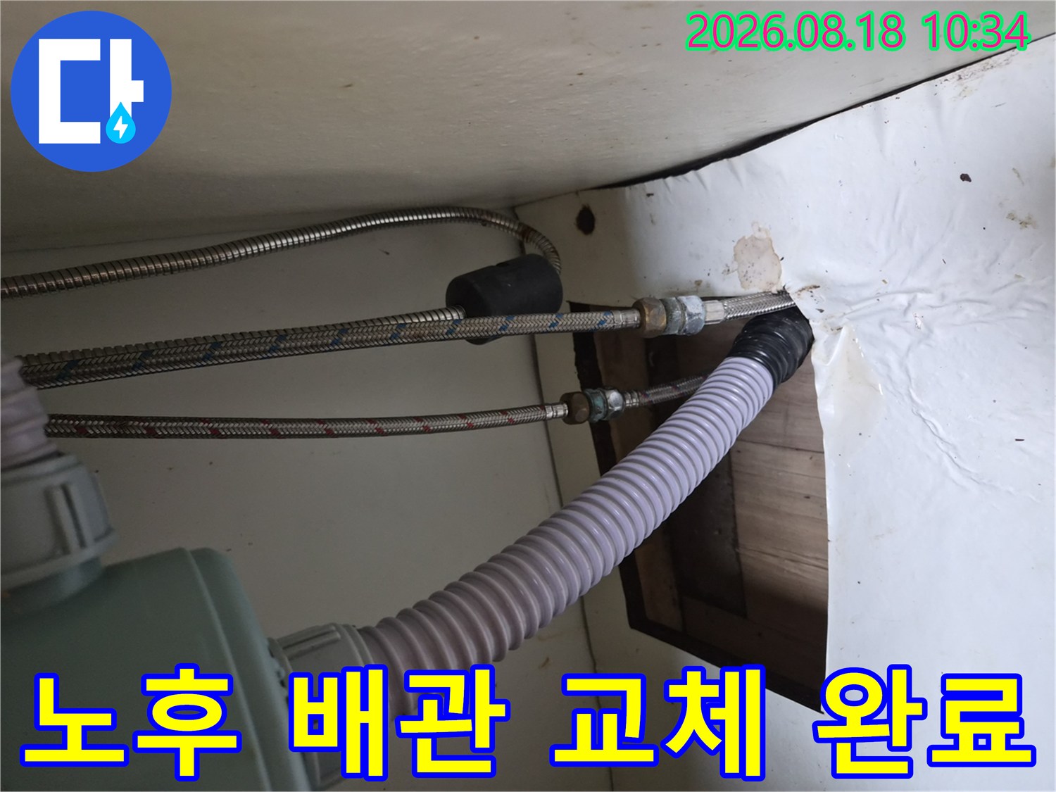 싱크대 하단부의 굵은 주름관과 스테인리스 호스 연결 부위 점검 사진입니다.