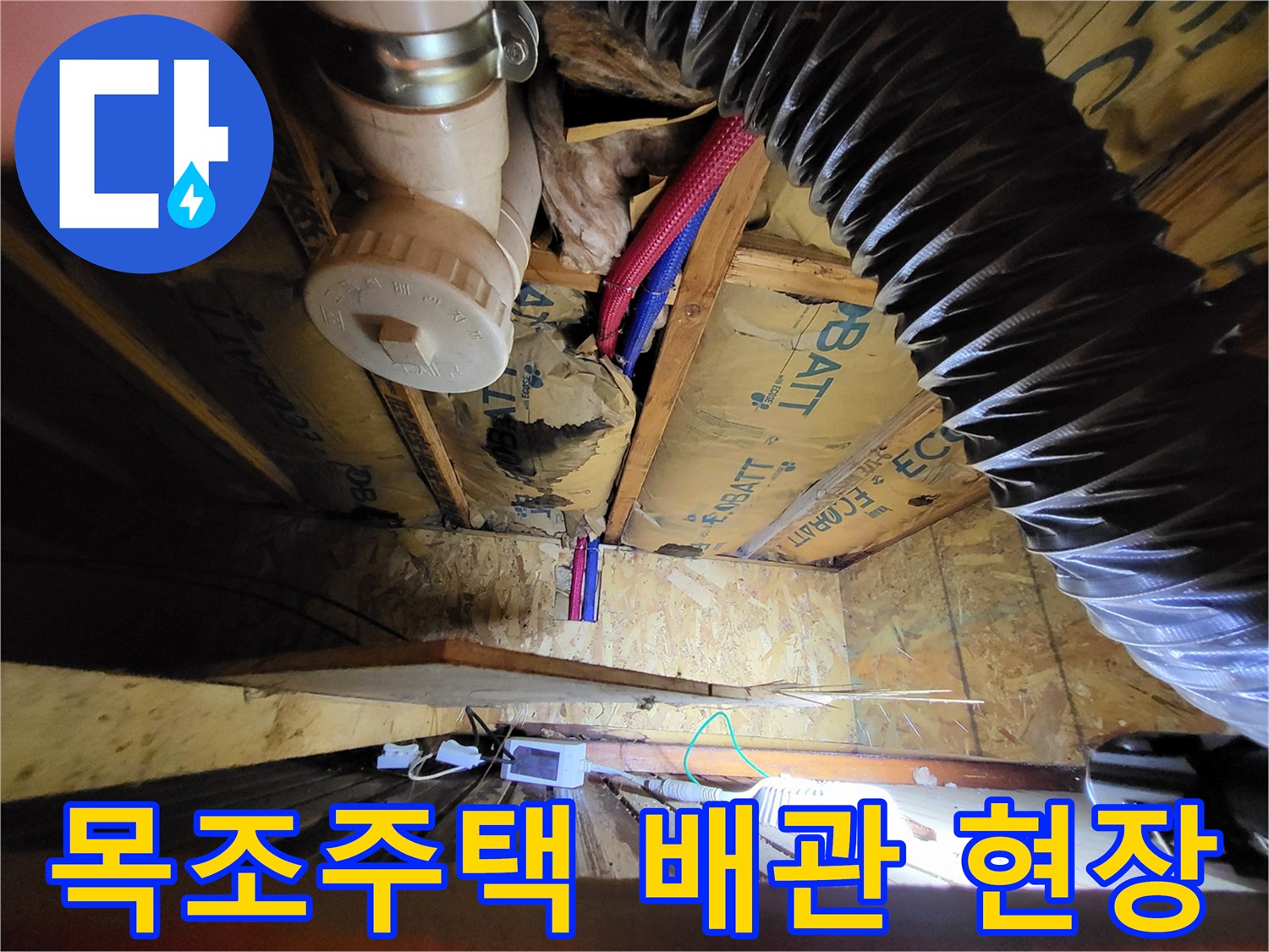 목조주트 천장 내부의 배관과 은색 트랩 구조물
