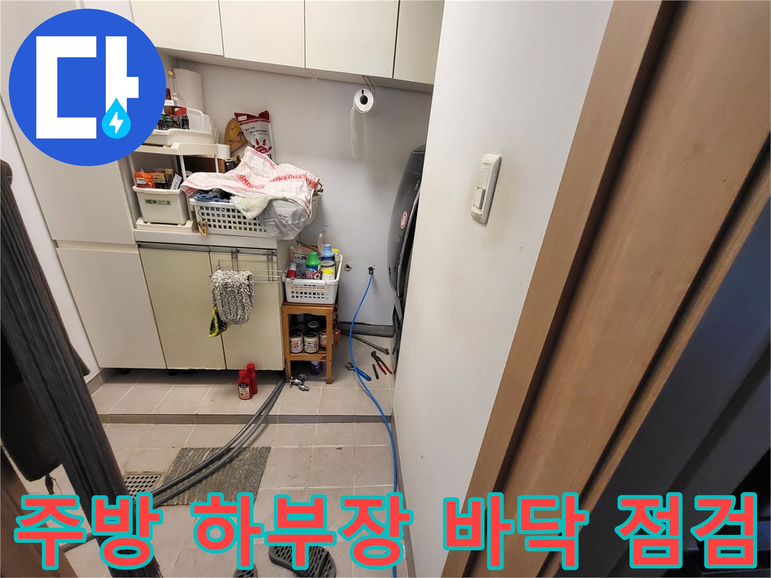 싱크대 아래쪽 좁은 공간에 설치된 배관 검사 장비와 호스