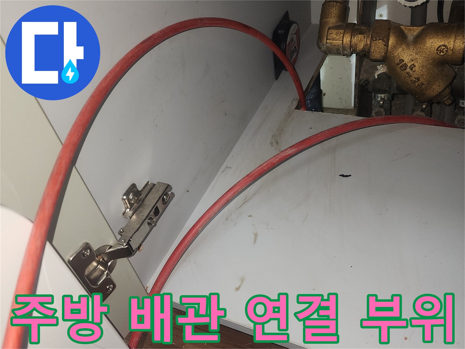 금속-배관과-붉은색-호스가-연결된-싱크대-하부-모습